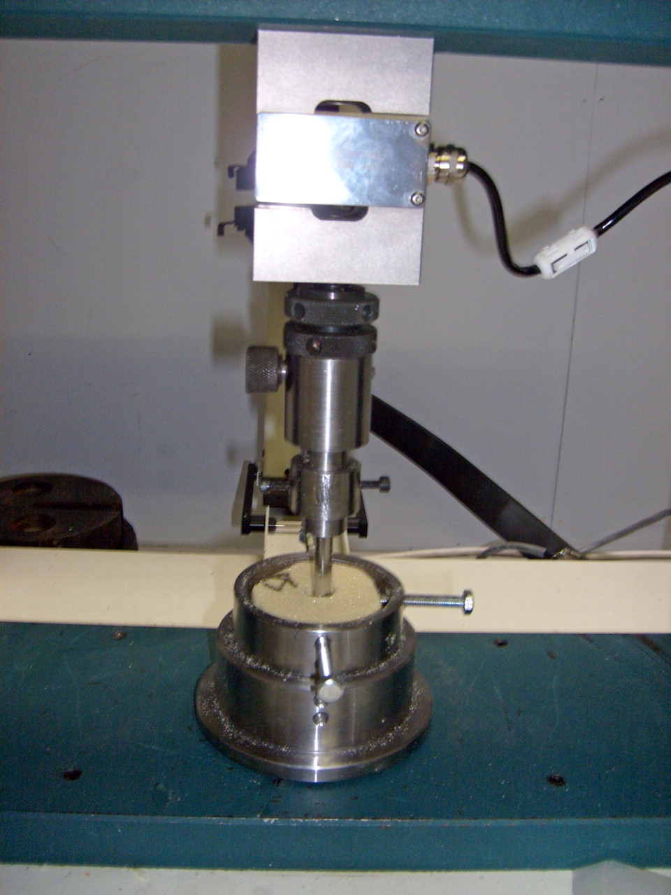 Fig. 1 
          Photograph showing the experimental
set-up for pushout testing of the implant in a synthetic bone construct.
        
